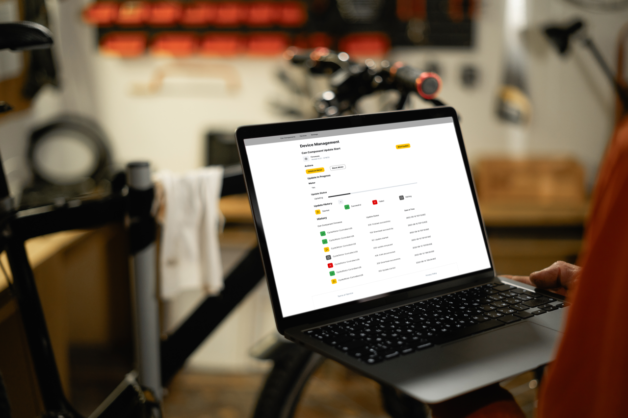 Open laptop with device, a CYCLE e-bike in the background